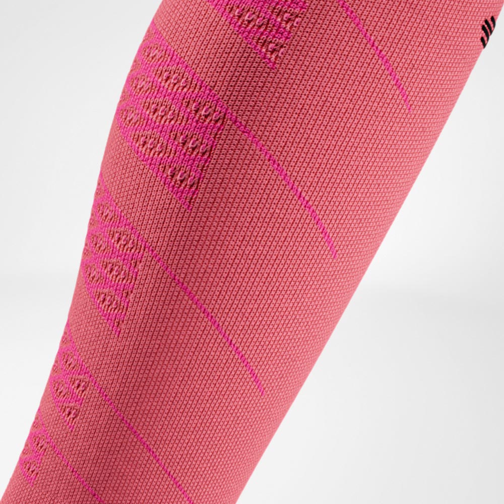 Dettaglio di una manica a compressione rosa per corridori. La trama lavorata garantisce compressione mirata e sostegno ai muscoli del polpaccio.