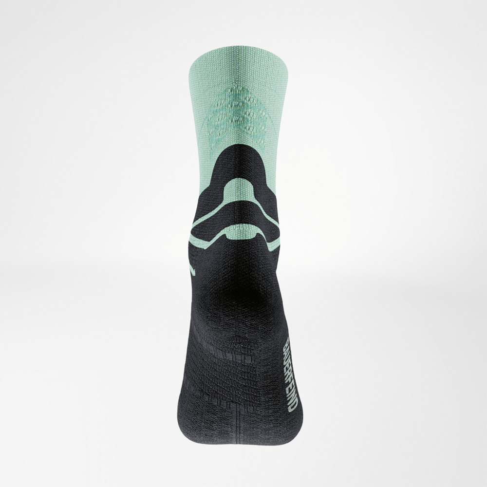 Vista posteriore della calza verde-nera Run Performance Midcut: gambale verde con 3D dots, zona comfort nera per il tendine d’Achille e logo BAUERFEIND sul lato.