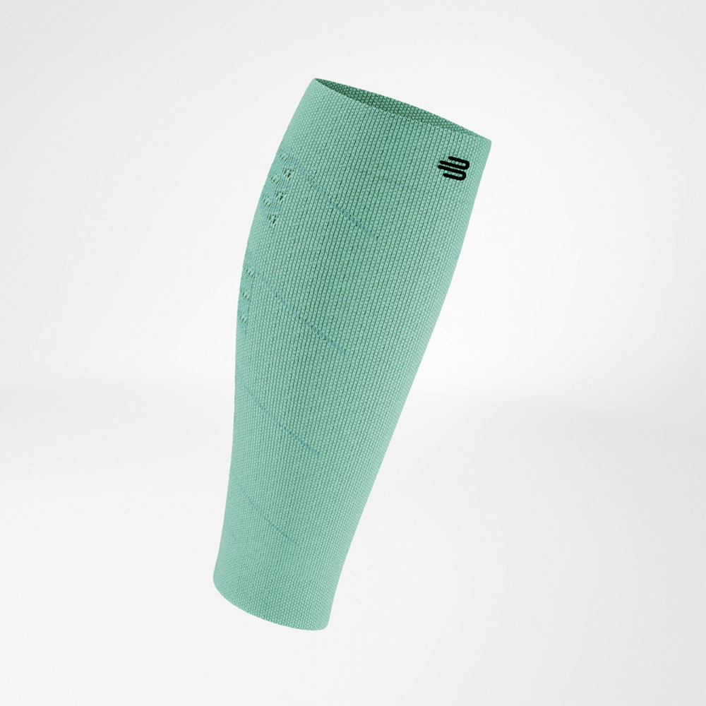 Vista frontale di una manica a compressione verde per il polpaccio. Il tessuto leggero e traspirante ha una trama uniforme con un logo sul bordo superiore.