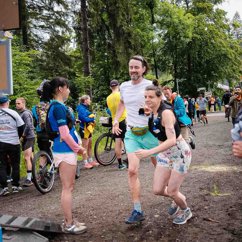 Correre insieme fino al traguardo Un uomo e una donna camminano insieme mentre alcune persone in bicicletta si trovano sullo sfondo