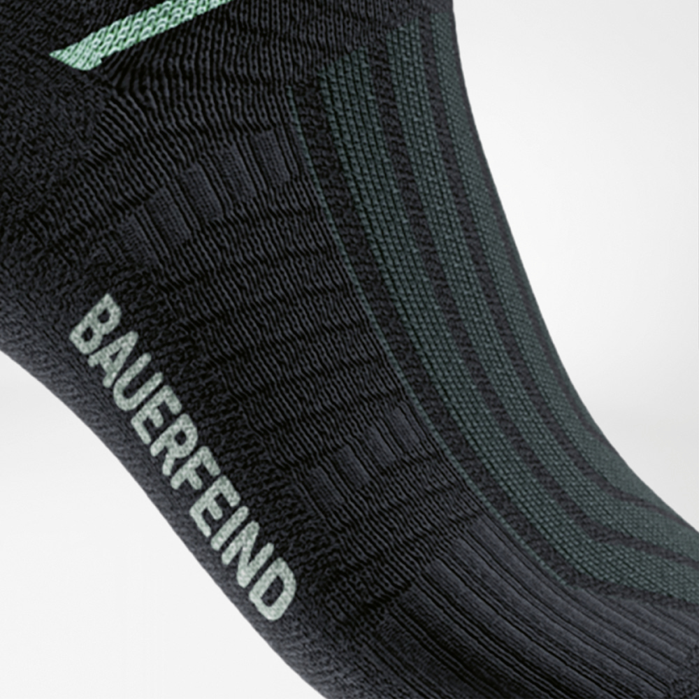 Dettaglio delle Run Performance Midcut Socks nere con elemento color menta nell’area dell’arco plantare. L’immagine mette in risalto la zona di compressione specifica che garantisce stabilità e supporto sicuro.