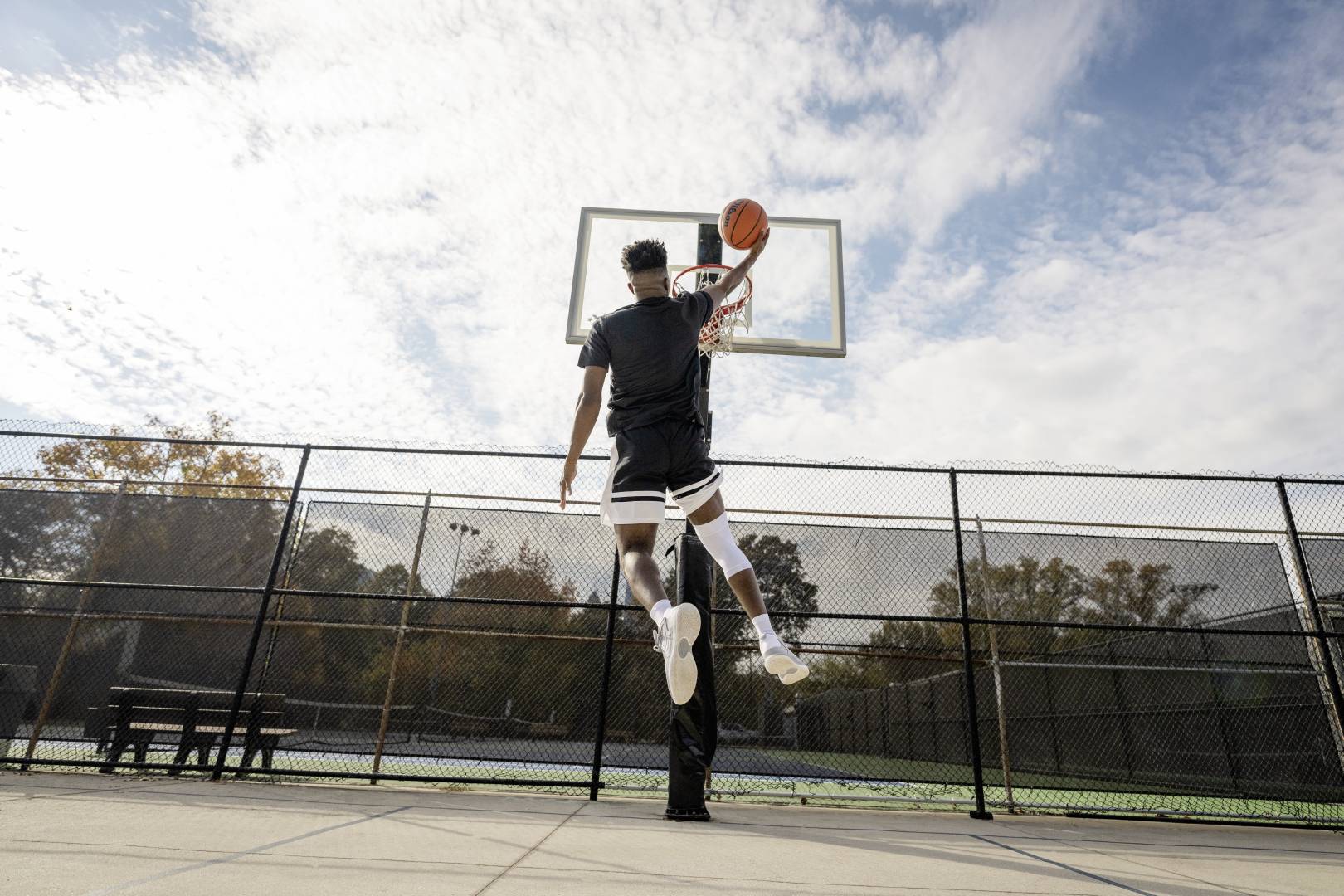 Giocatori di basket con una fascia bianca al ginocchio durante le cocche su un campo di streetball