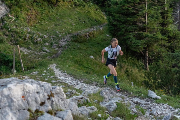 Il corridore ha calzini da corsa e faceva jogging su un terreno pietroso e collinare nella foresta