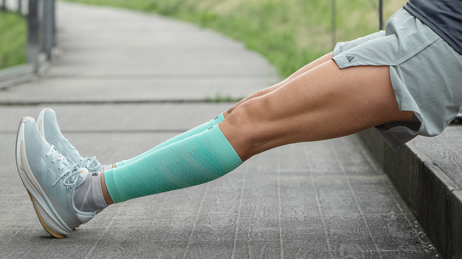 Lo stretching dopo la corsa può supportare la rigenerazione, soprattutto dopo sessioni di allenamento per maratona più lunghe Breaker in rosa Calzini in corsa allunga i polpacci seduti sul pavimento e sorride