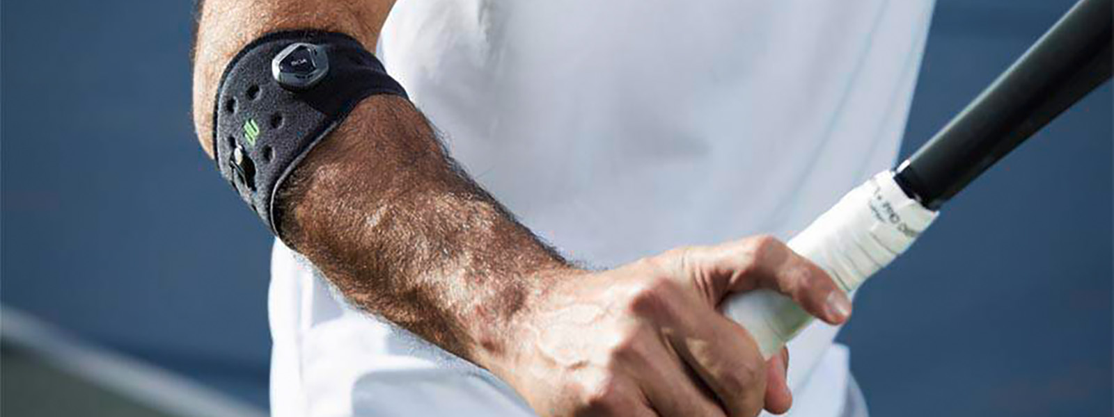 La cinghia del gomito sportivo impedisce un braccio di tennis e supporta il tuo gioco da tennis Tennis Player con un bandage del gomito ha una racchetta da tennis in mano