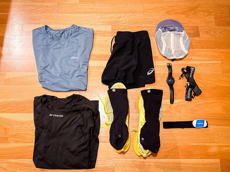 Abbigliamento e attrezzatura da corsa per mezza maratona - Preparazione per il giorno della gara Preparativi per la mezza maratona: Un outfit completo per il giorno della gara, con abbigliamento tecnico blu, scarpe da corsa gialle e accessori come il cardiofrequenzimetro e l'orologio da corsa, pronto per essere indossato.
