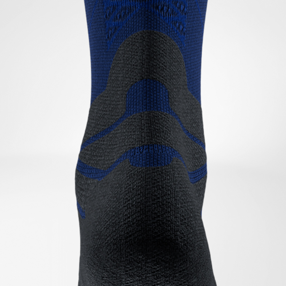 Dettaglio di una calza da running blu e nera di Bauerfeind Sports, vista posteriore all’altezza del tendine d’Achille. L’imbottitura protegge il tendine dallo sfregamento nella scarpa.