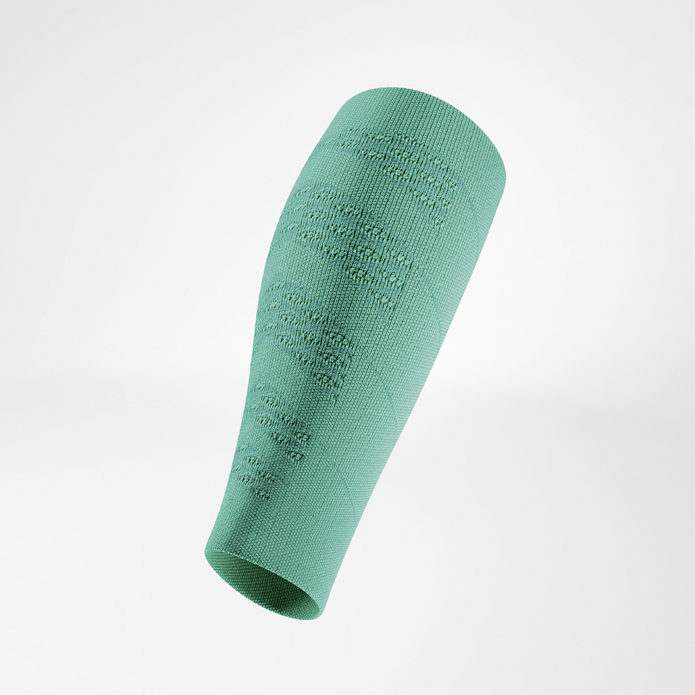 Sleeve a compressione verde in vista laterale inclinata, sospesa. Il tessuto a maglia fitta evidenzia zone strutturate che garantiscono stabilità e ventilazione.