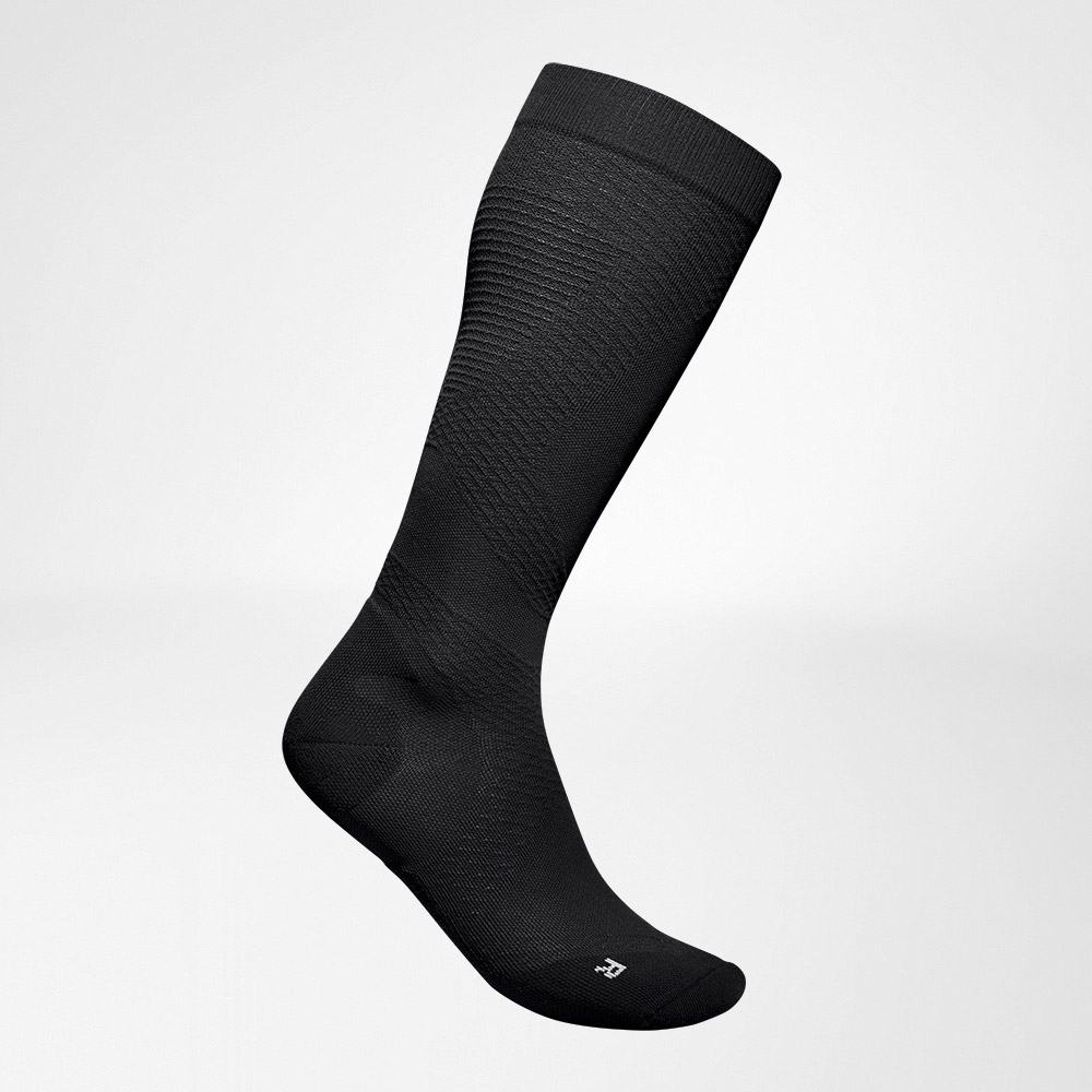 Vista completa laterale delle calze a compressione nere, ariose e lavorate a maglia da eseguire