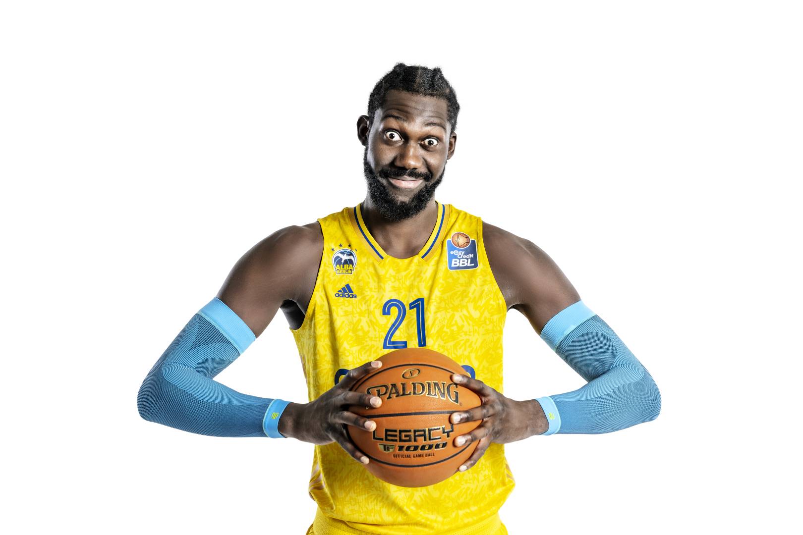 Il giocatore di Alba Berlin tiene il basket tra le mani e indossa una manica a braccio