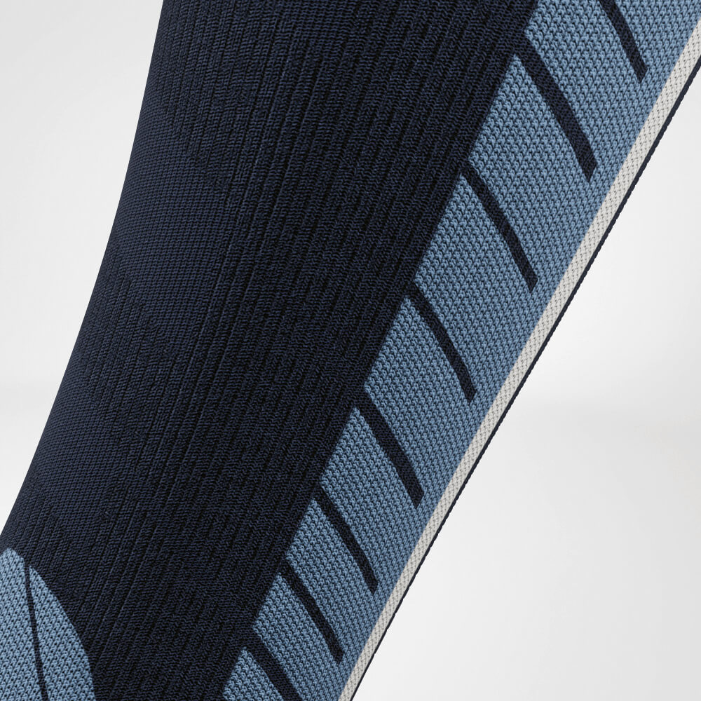 Primo piano del polpaccio di un calzino a compressione da sci blu con motivo a maglia dettagliato per una maggiore traspirabilità e supporto. Ideale per lunghe giornate sulle piste.