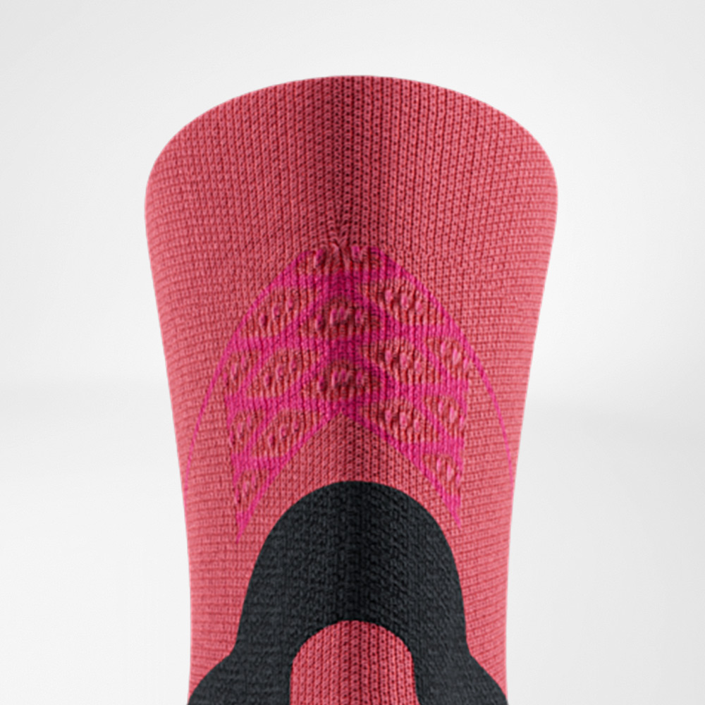 Primo piano delle Run Performance Midcut Socks rosse con accenti rosa sul bordo. La struttura a maglia evidenzia le zone funzionali integrate che garantiscono stabilità e traspirabilità.