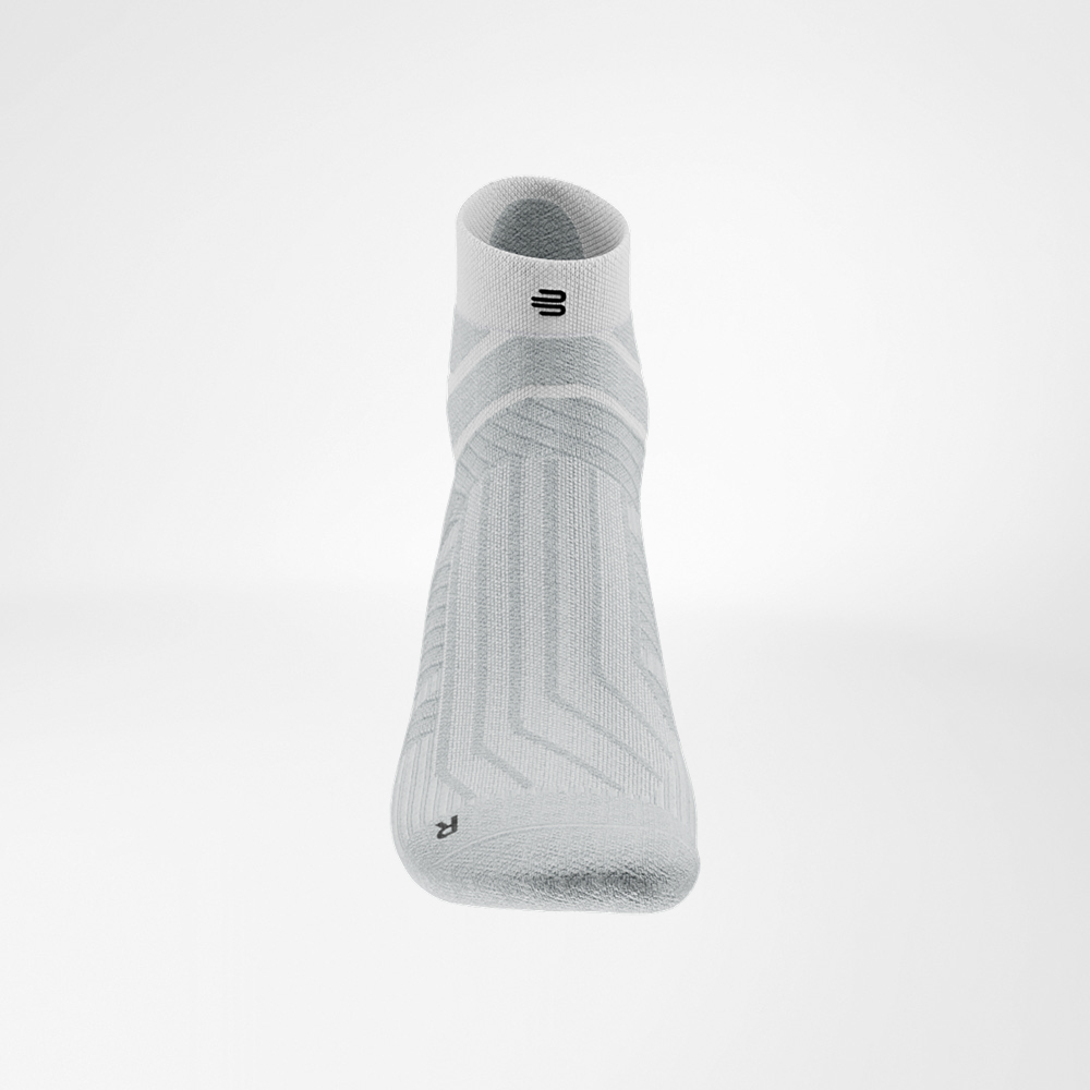 Leggerezza fresca in bianco Calza bianca Run Performance Low Cut di Bauerfeind, dettaglio del collo del piede con tessuto traspirante e logo nero sul bordo elastico.
