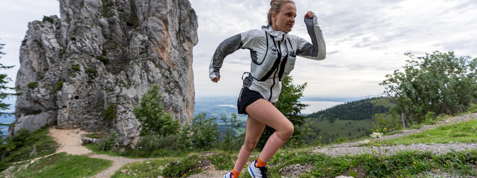 Trail Run Socks Peach in azione Hahner Zwilling corre su una montagna e indossa i calzini della pista nella pesca del colore