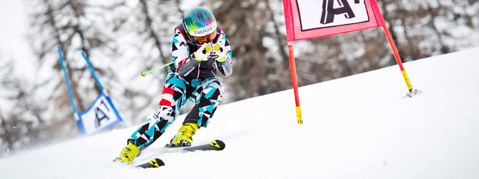 Lo slalom gigante combina curve impegnative con l'accelerazione di una discesa Ski Runner in un abito da corsa blu e bianco-bianco va in posizione di partenza dopo aver superato un grande gol