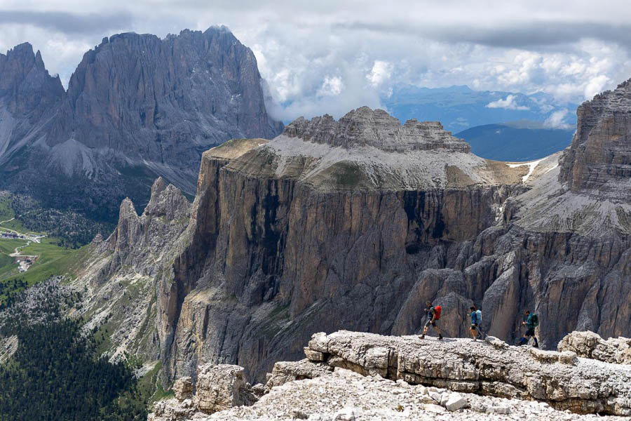 Paesaggio straordinario nelle Dolomiti Scatto paesaggistico di molte montagne nelle Dolomiti, con tre escursionisti che camminano sulla cima in primo piano.