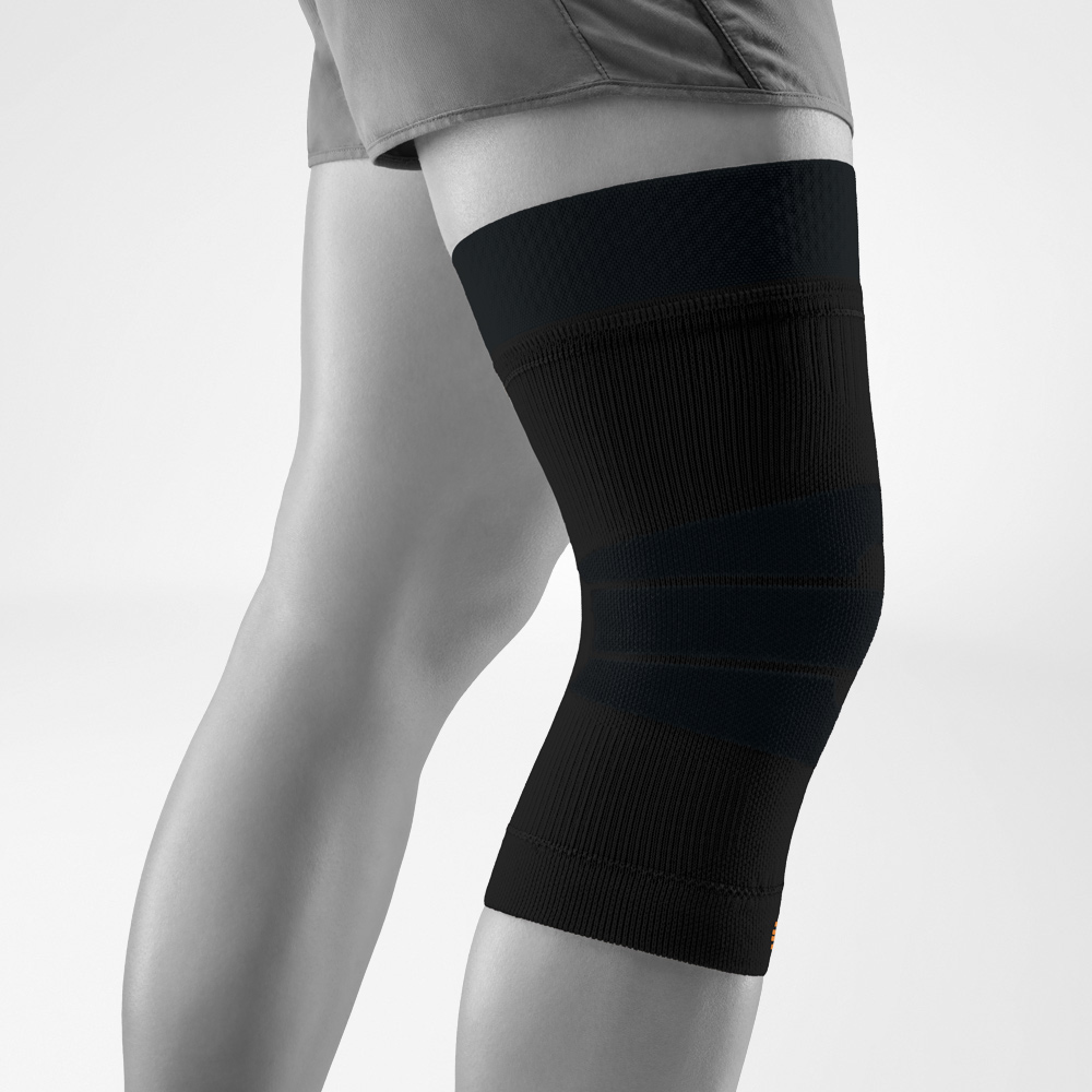 Ginocchiera nera per attività outdoor, vista laterale in studio. La maglia elastica stabilizza l’articolazione del ginocchio, mentre la compressione favorisce la circolazione e la libertà di movimento all’aperto.