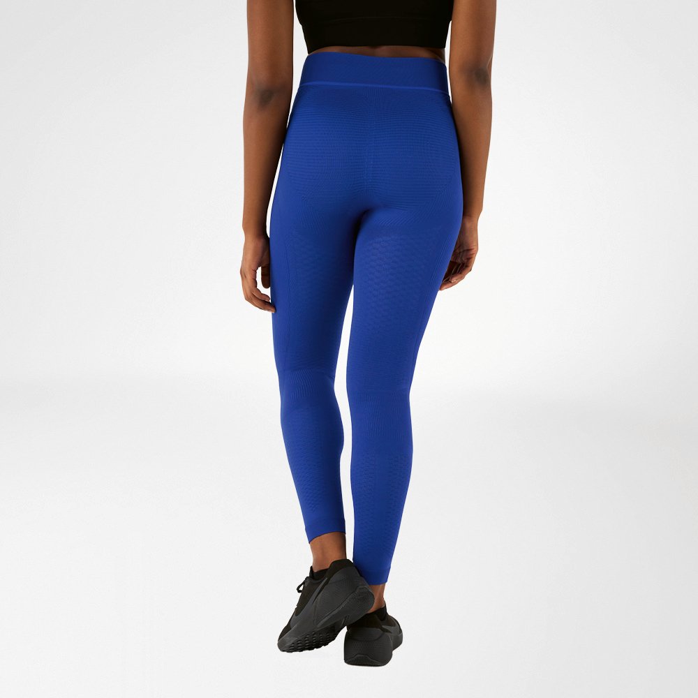 Una donna fotografata da dietro con pantaloni compressivi blu navy.