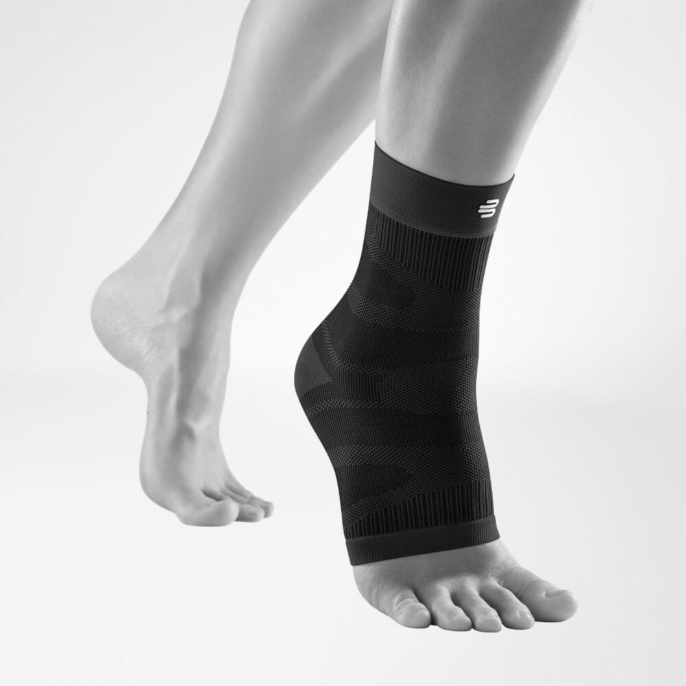 Vista completa del supporto alla caviglia a compressione nera su una gamba grigia stilizzata