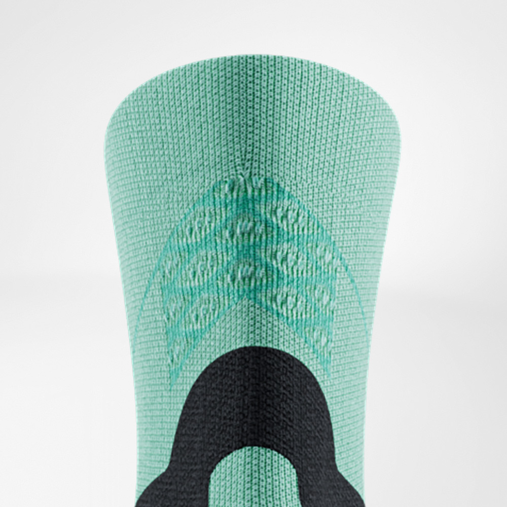 Dettaglio della parte superiore di una calza Run Performance Midcut verde di Bauerfeind. Sono chiaramente visibili le strutture tessute nella sezione superiore e un rinforzo nero che offre sostegno e stabilità.