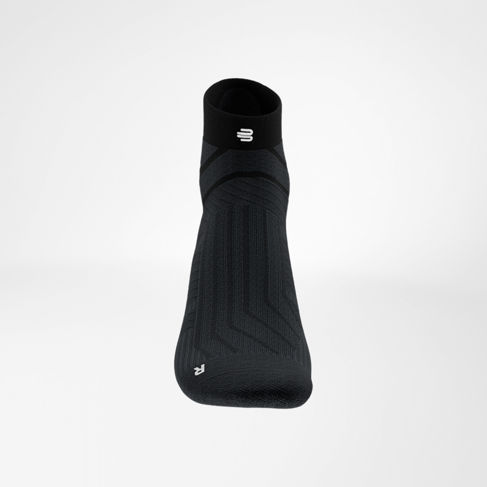 Dettaglio del bordo della calza nera Run Performance Low Cut di Bauerfeind, con il logo B bianco e la struttura a coste sottili.