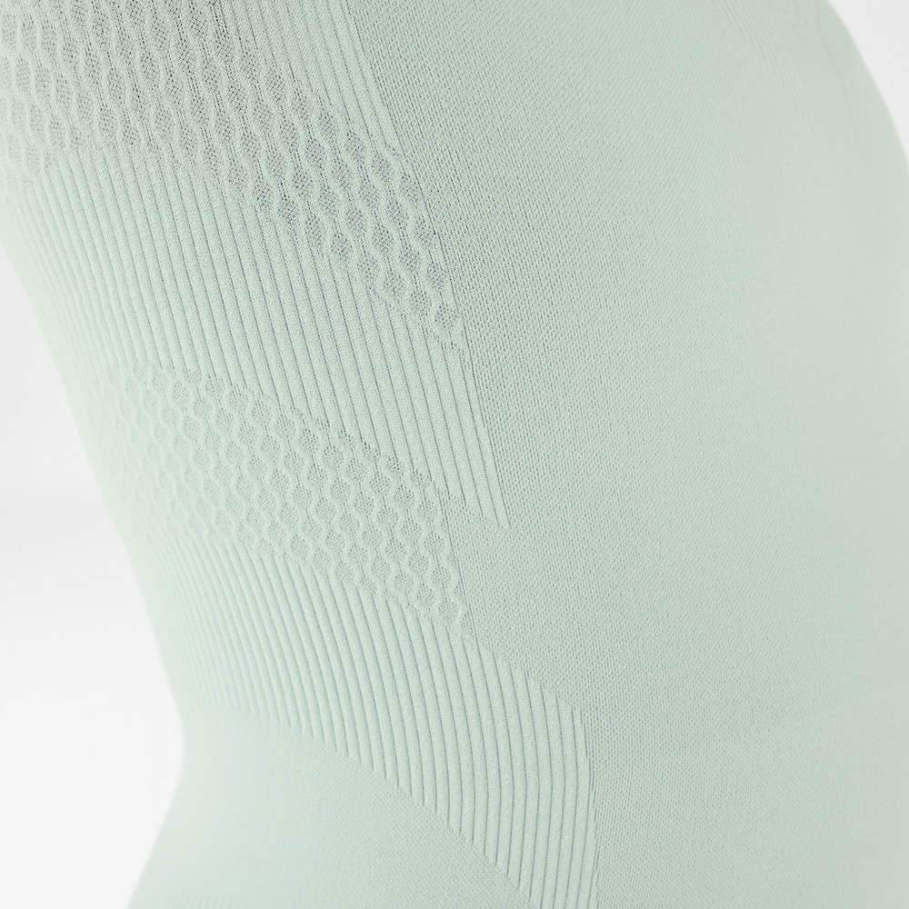 Primo piano di una calza compressiva grigia con diversi motivi di texture.