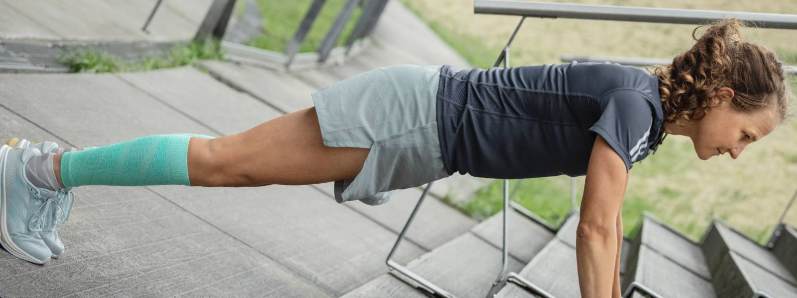 La donna mette flessioni su una vista a pavimento in cemento di diagonale