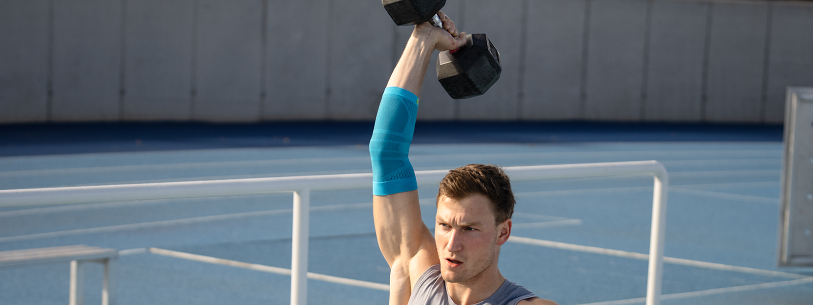 Ellenbogen Bandage durante l'allenamento di fitness Thoms Röhler regge un peso e stabilizza il braccio usando una fasciatura del gomito