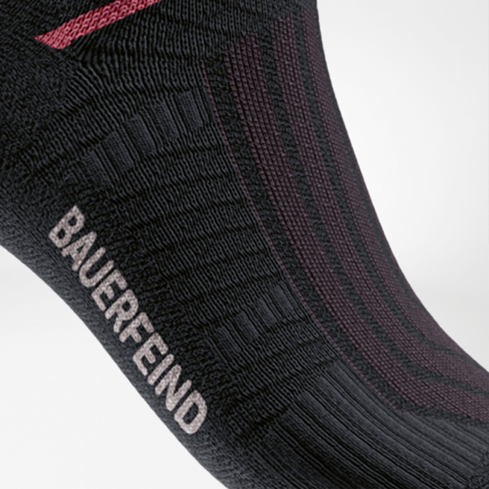 Dettaglio delle Run Performance Midcut Socks nere con elemento rosso nell’area dell’arco plantare. L’immagine mette in evidenza la zona di compressione rinforzata per una stabilità ottimale e un supporto sicuro.