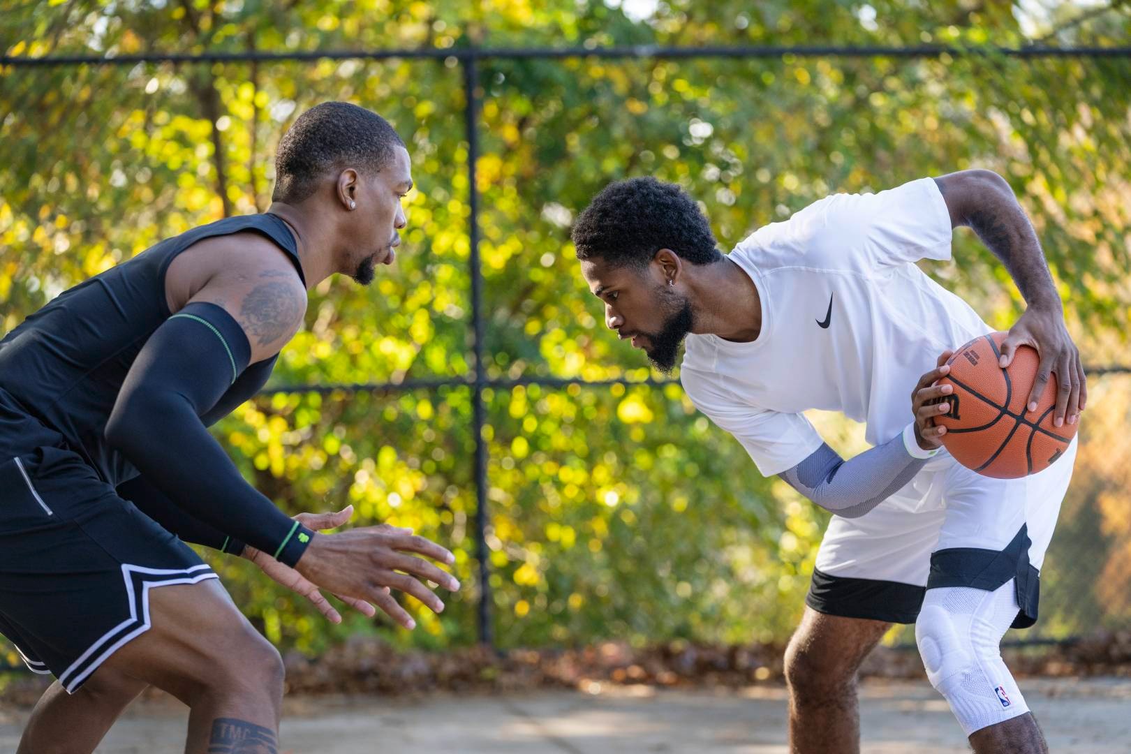 Streetball Player in White Game Clothes cerca di giocare al suo avversario in Black Game Clothes