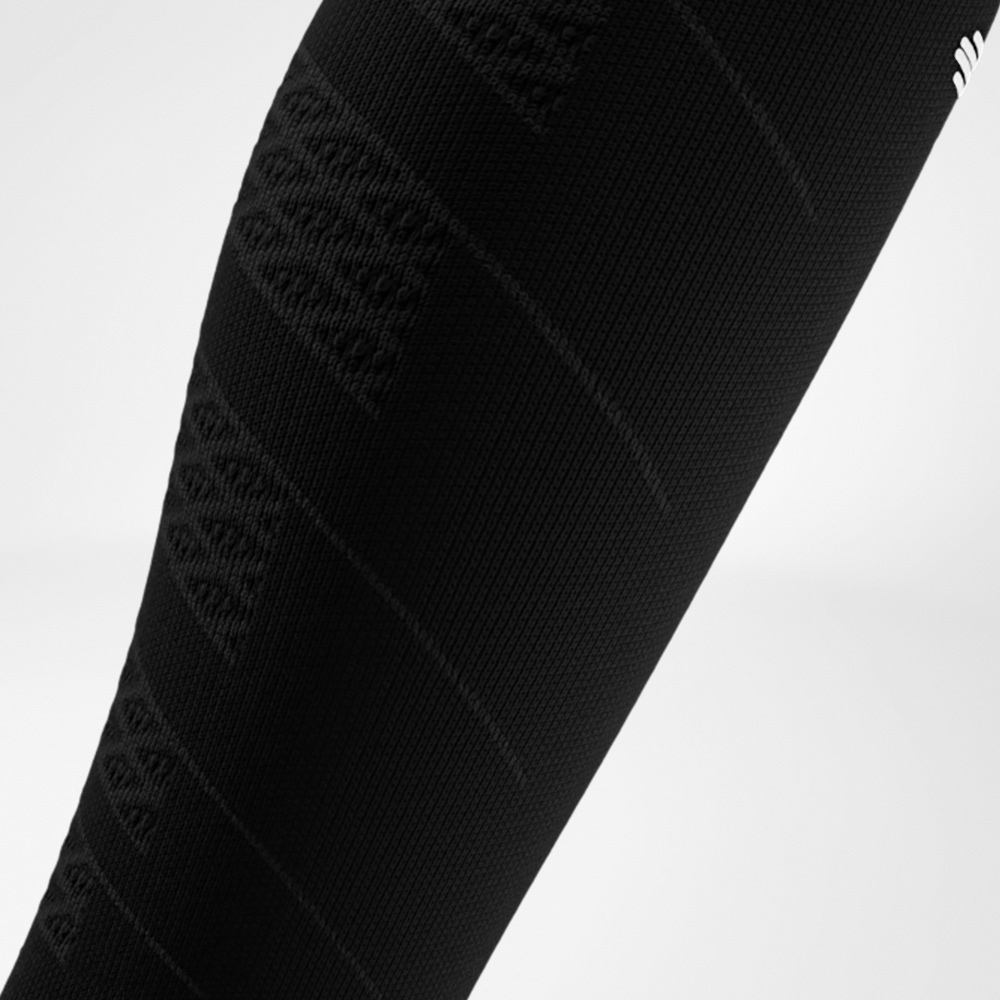 Primo piano di una Run Performance Compression Sleeve nera sulla parte inferiore della gamba, con una fine struttura a maglia che offre compressione mirata e sostiene i muscoli del polpaccio durante la corsa.