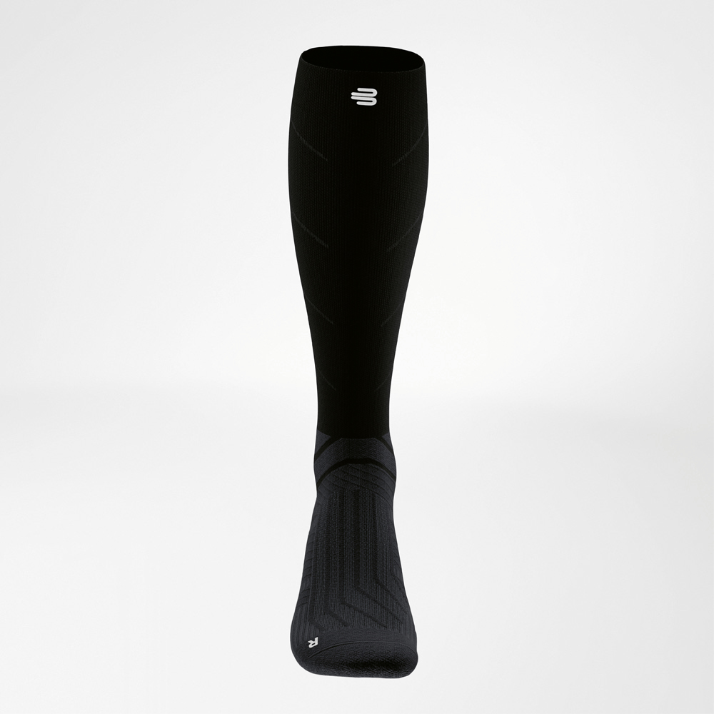 Calza a compressione frontale con struttura dinamica Vista frontale di una calza a compressione nera lunga con struttura continua per supportare piede e polpaccio durante l’allenamento.