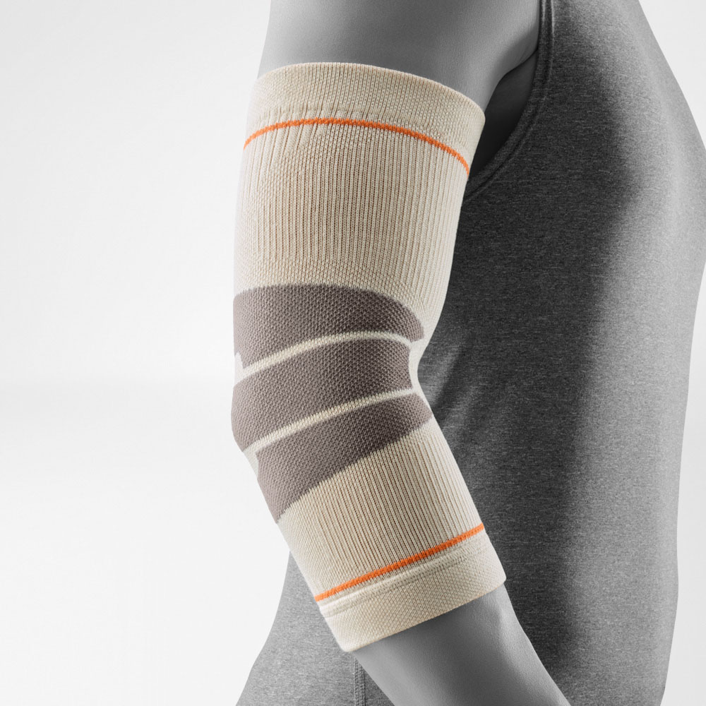 La Outdoor Compression Elbow Support color sandstone indossata sul braccio. La fascia aderisce perfettamente al gomito e mette in evidenza le zone di compressione anatomiche, offrendo supporto stabile e comfort