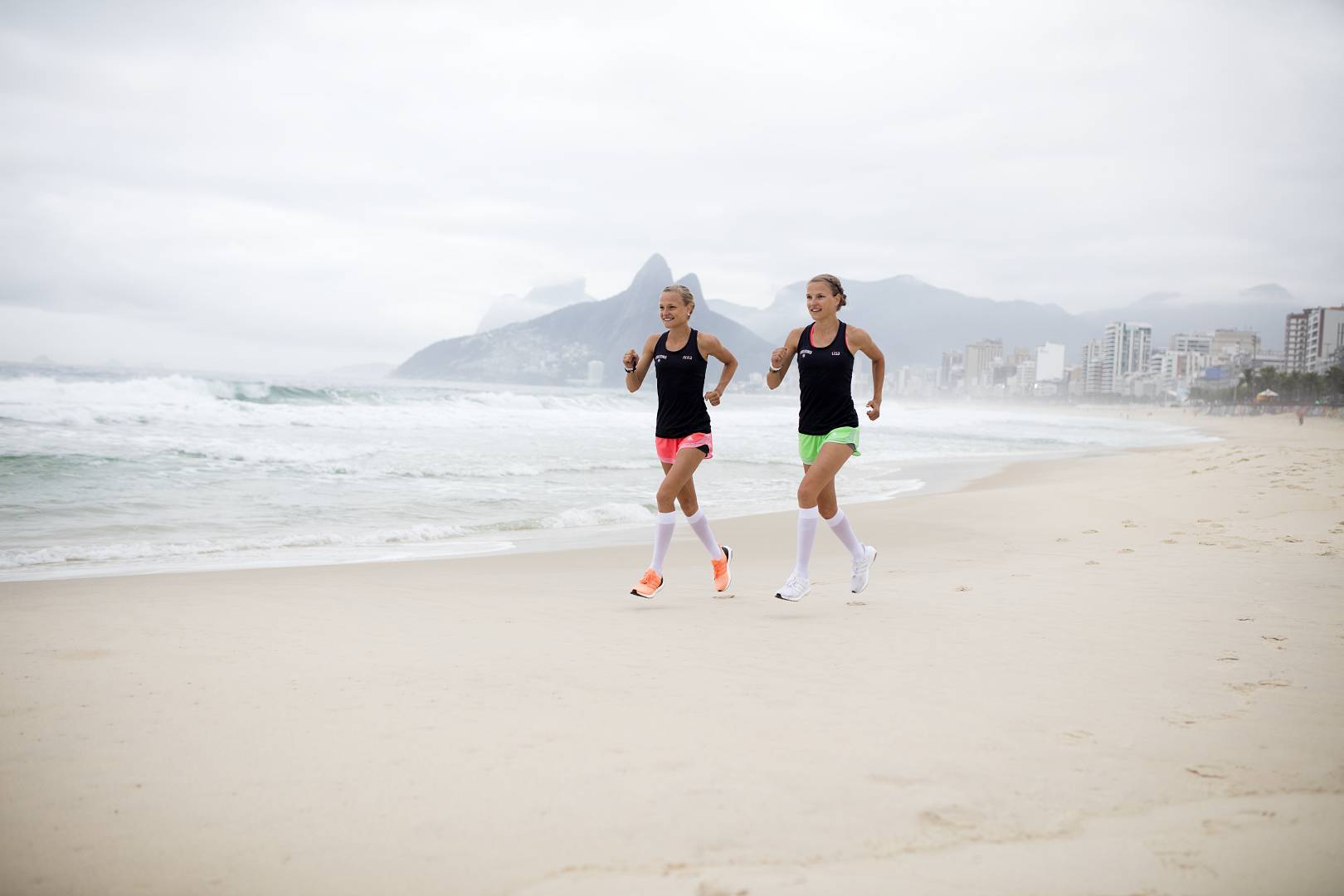I gemelli corrono sulla spiaggia di Rio con calzini da corsa bianchi