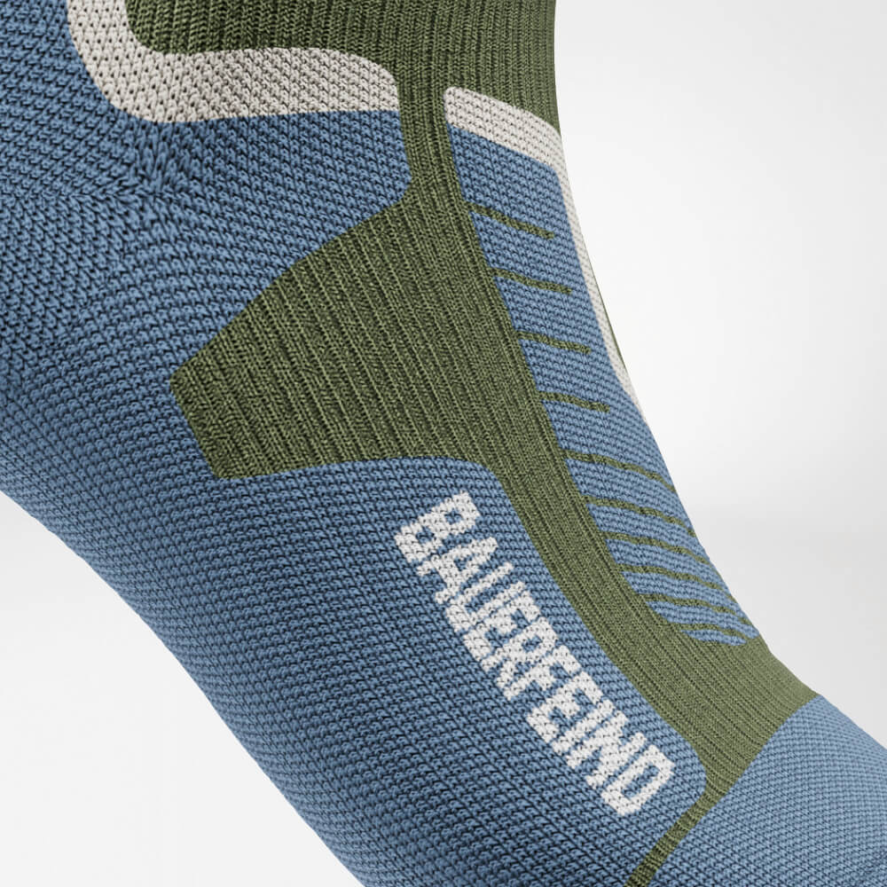 Primo piano del collo del piede di un calzino a compressione da sci verde con motivo a maglia ergonomico rinforzato. Offre supporto ottimale e distribuzione della pressione per il massimo comfort durante le attività sportive intense.