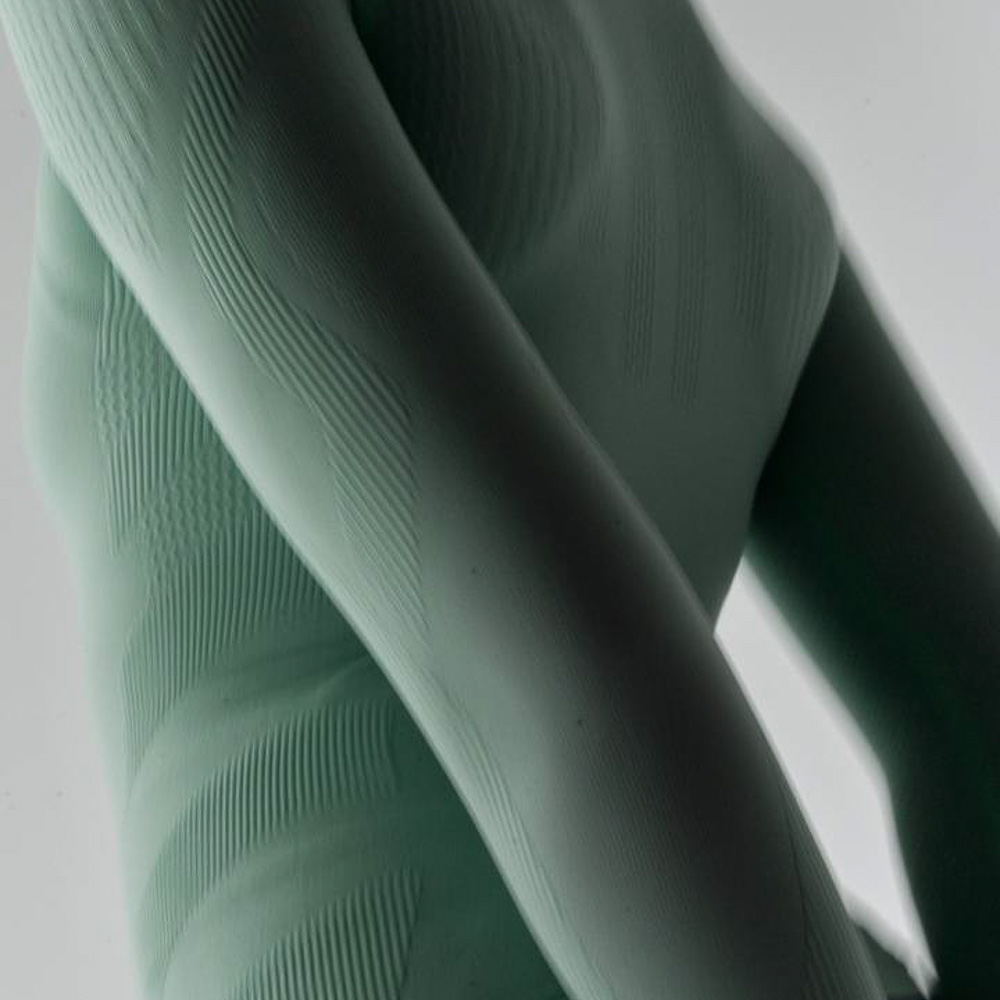 Top sportivo e compressivo verde chiaro Parte superiore del corpo di una donna che indossa un top sportivo verde chiaro