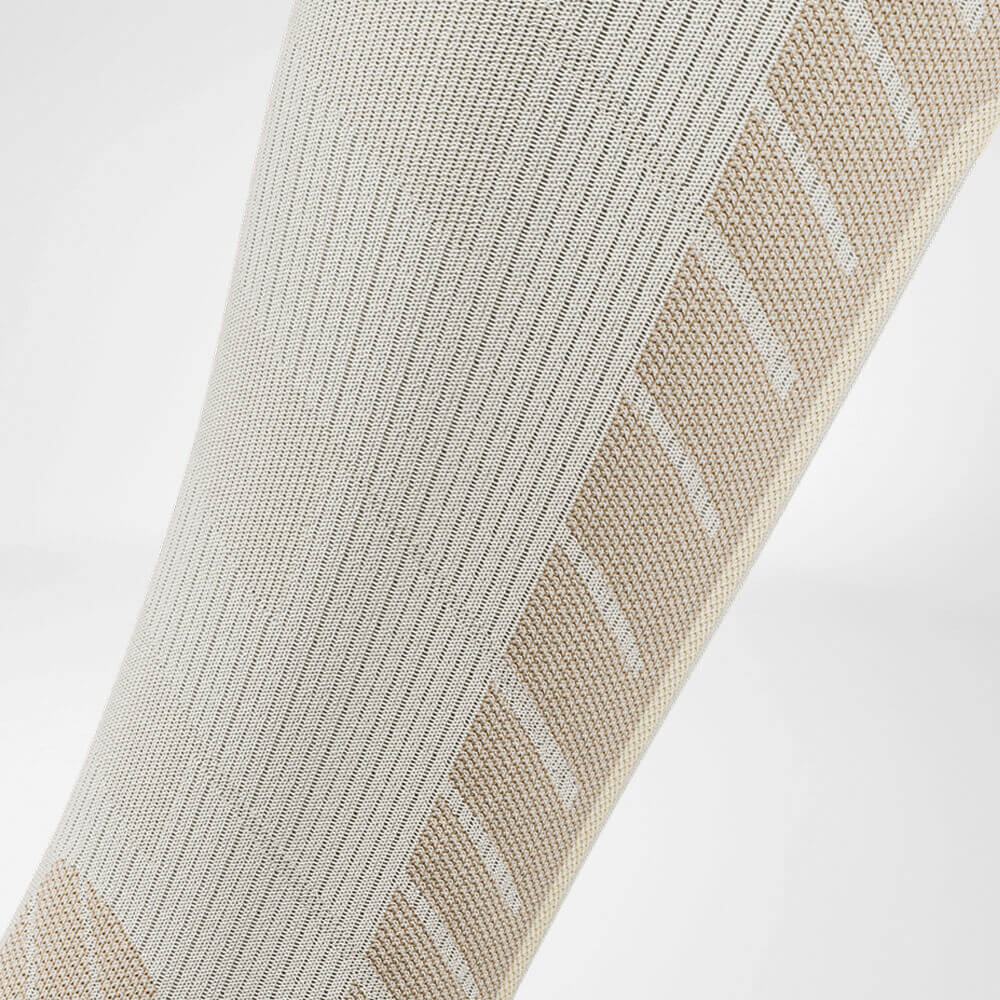 Calzino da sci da discesa con lana merino beige dettaglio zona di compressione Vista dettagliata della zona di compressione del polpaccio delle calze sportive beige per lo sci con lana merino