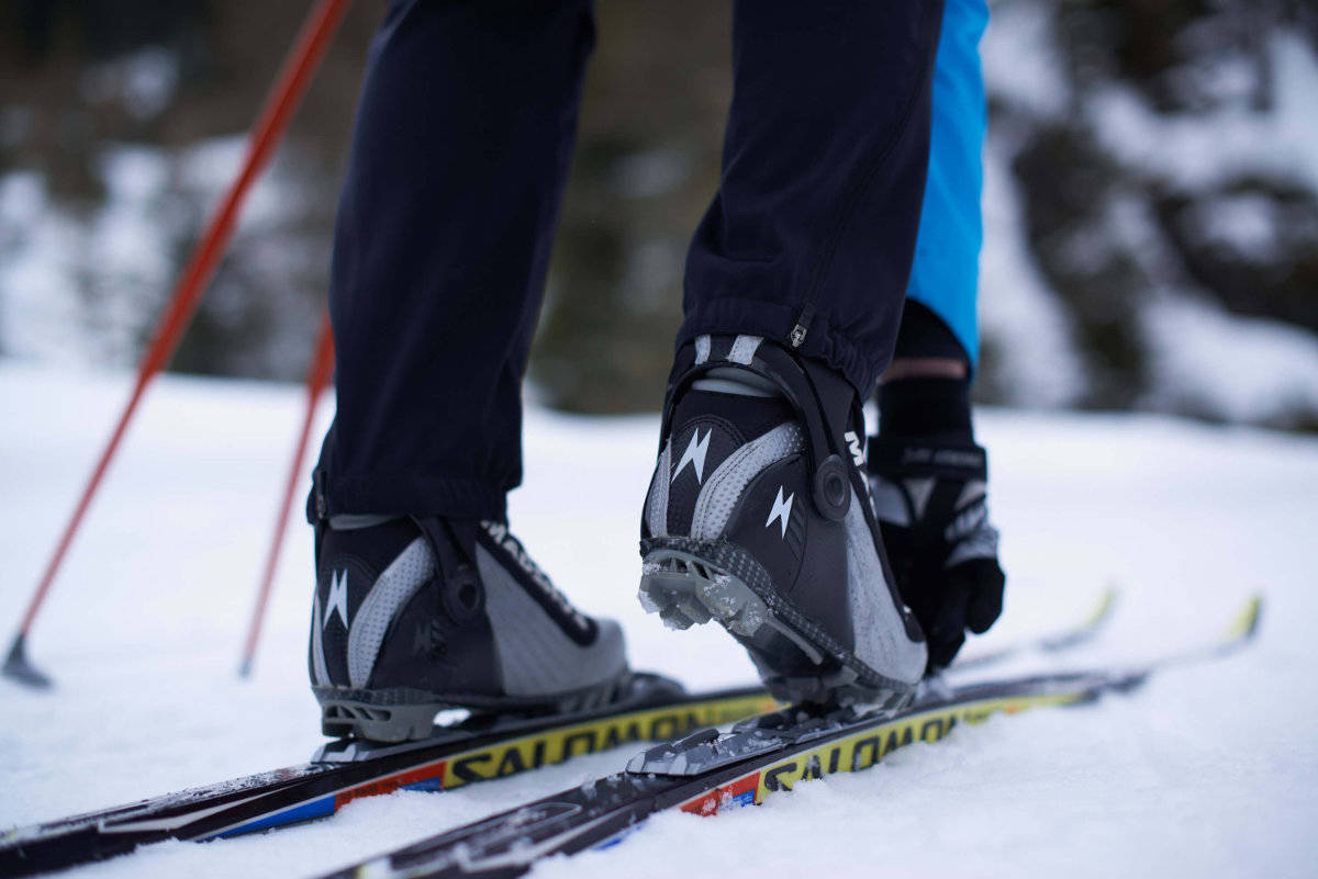 La rilegatura non è uguale a un legame: vedi se sei migliore o SNS Uno sciano di fondo si piega le scarpe al primo piano degli sci