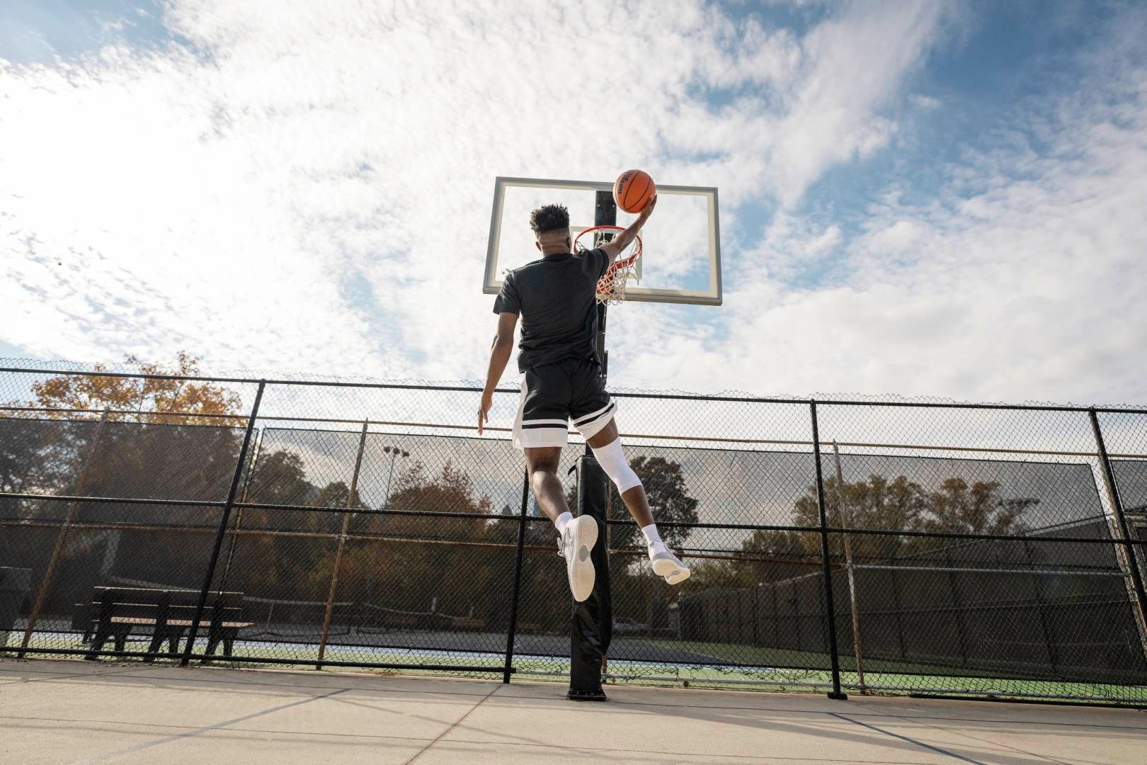 Giocatori di basket con una fascia bianca al ginocchio durante le cocche su un campo di streetball