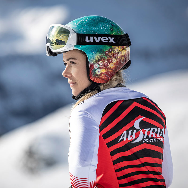 Andrea Limbacher a volte premuroso Chiudi uno sciatore con un abito da corsa rosso e nero e un elmetto scintillante colorato che guarda il lato