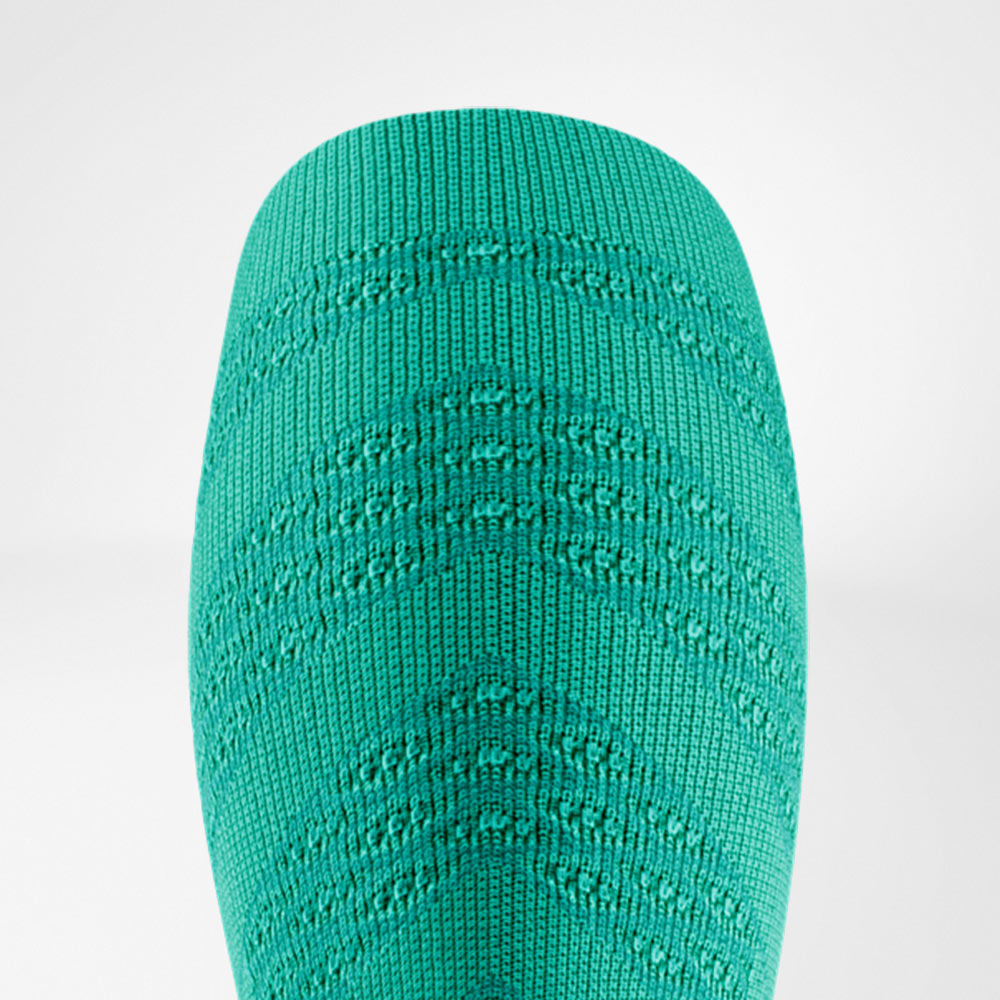 Dettaglio di una manica a compressione verde brillante con un motivo strutturato ben definito. Il materiale appare dinamico e trasmette stabilità ed energia per allenamenti intensi.