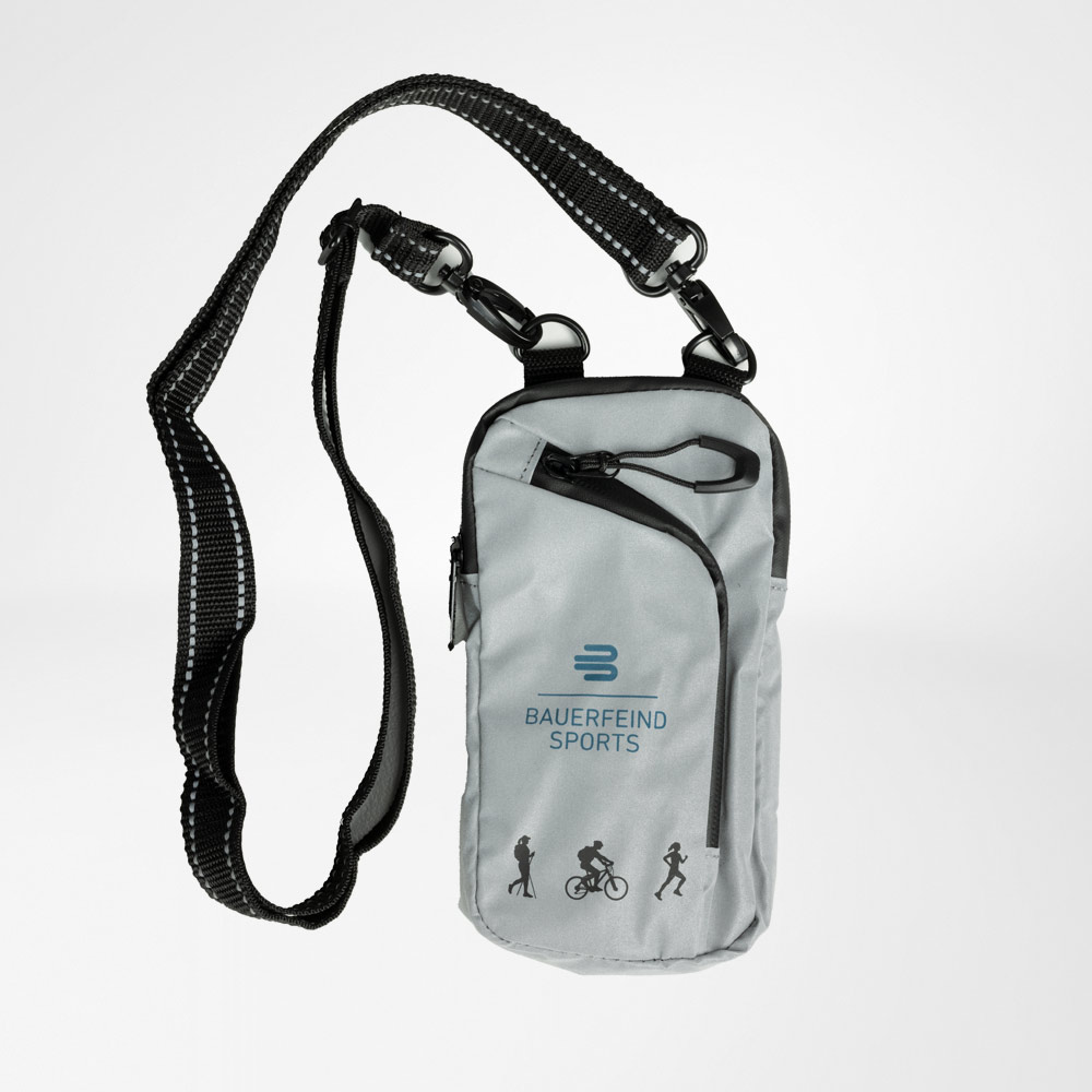 Borsa a tracolla riflettente per sport all'aperto Borsa a tracolla riflettente con tracolla regolabile e resistente. Sul davanti, il logo Bauerfeind Sports e le icone per vari sport. La borsa ha diverse tasche con cerniera.