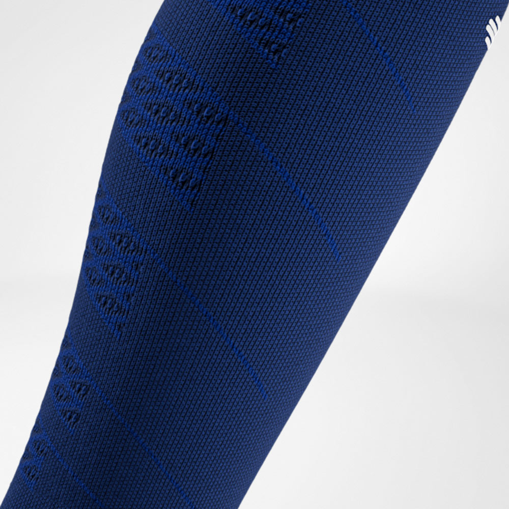 Dettaglio di una sleeve blu navy con tessitura fine e zone di compressione integrate sul polpaccio.