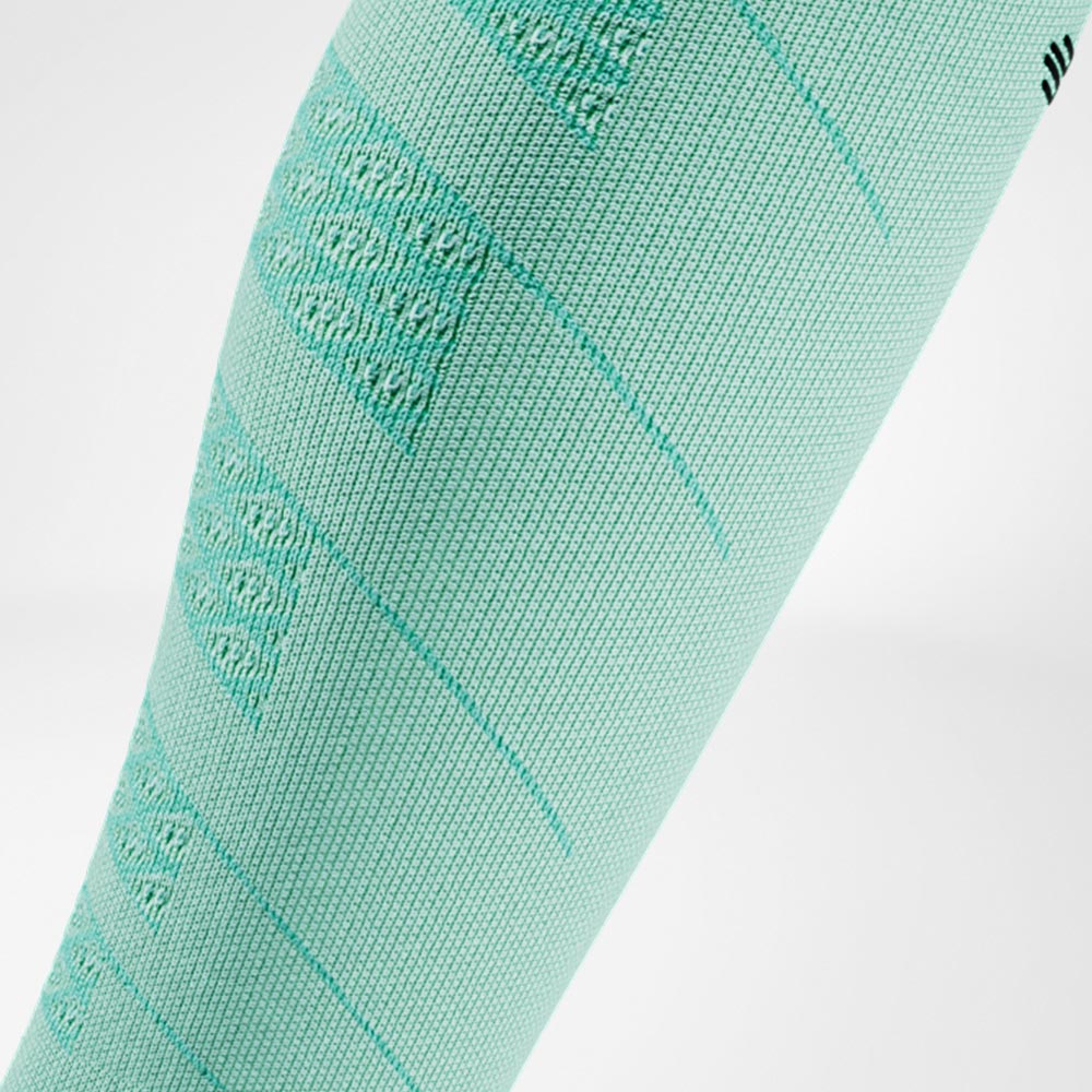 Primo piano di una Run Performance Compression Sleeve verde menta sulla parte inferiore della gamba, con struttura a maglia traspirante che garantisce una compressione leggera e confortevole.