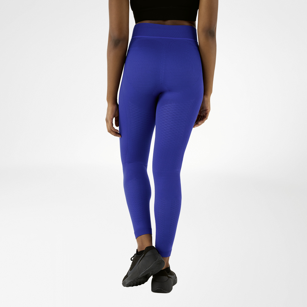 Una donna fotografata da dietro con pantaloni compressivi blu navy.