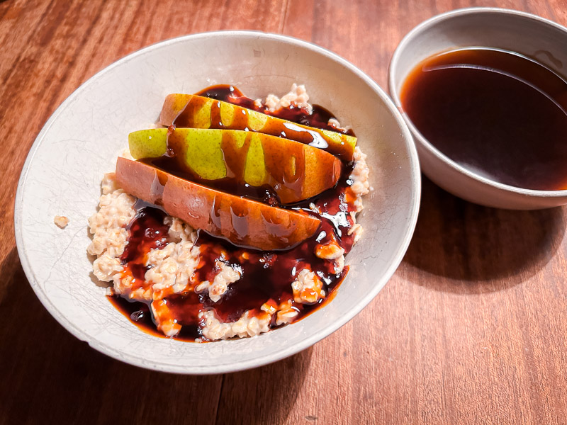 Porridge con pere e sciroppo come fonte di energia per il carbo-loading prima di una mezza maratona. Una colazione di porridge con pere e sciroppo, perfetta per un'energia a lunga durata prima di una mezza maratona.