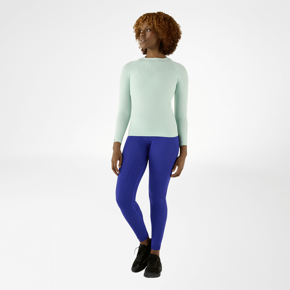 Donna con maglia a maniche lunghe blu aderente e pantaloni a compressione blu, vista frontale