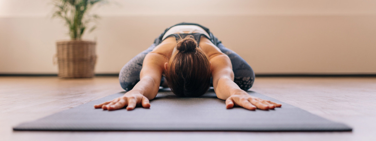 Yoga contro il mal di schiena - La donna inondato ha messo la testa in avanti tra le braccia sul tappeto
