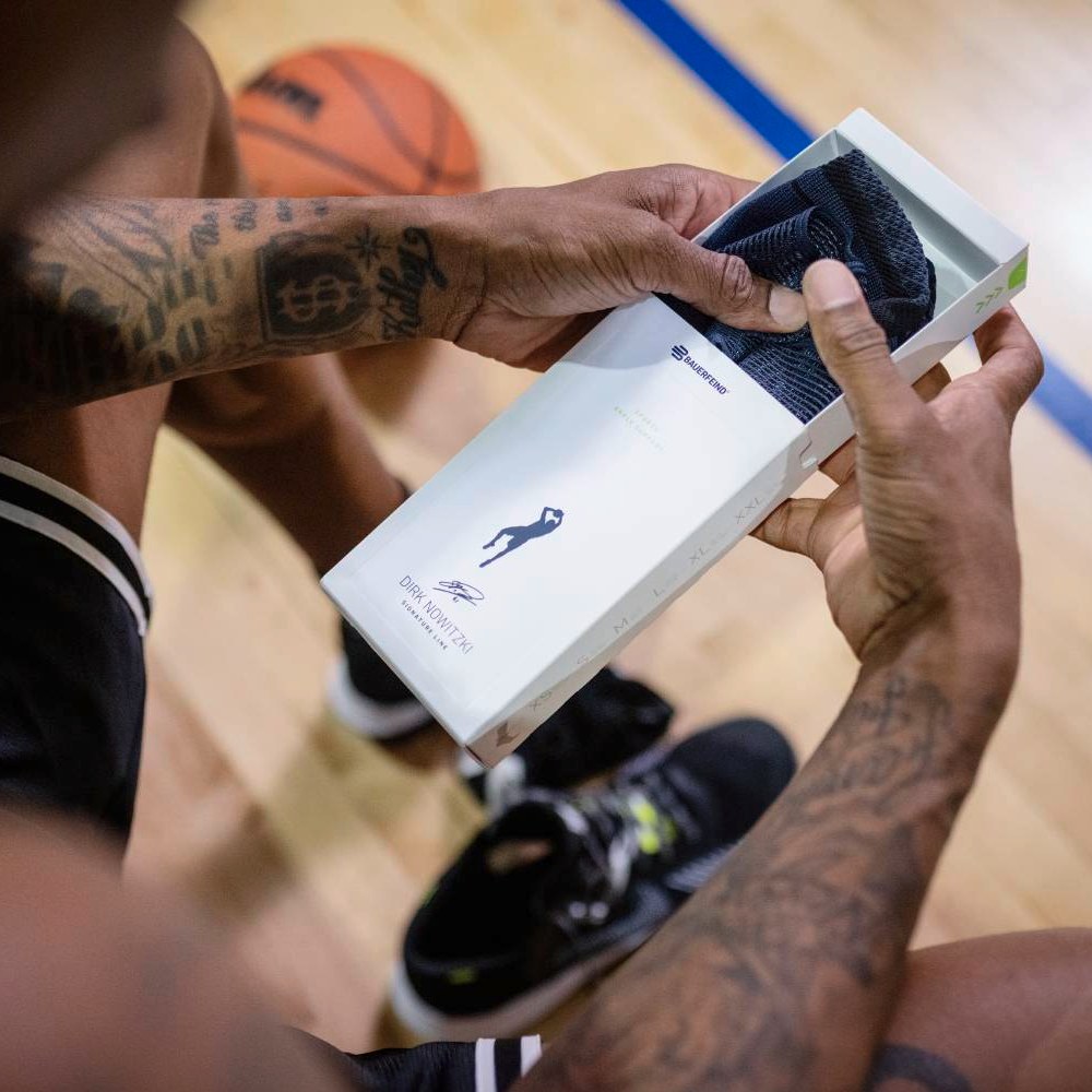 Un atleta apre una confezione contenente il supporto per caviglia Dirk Nowitzki Special Edition.