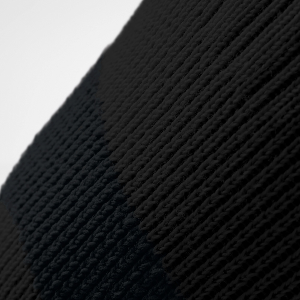 Primo piano della ginocchiera nera. La struttura a maglia fine evidenzia la lavorazione resistente che offre stabilità e flessibilità nei movimenti all’aperto.